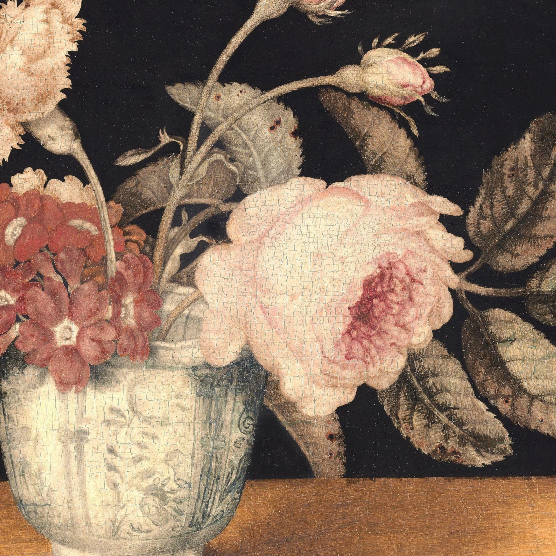 Floral arrangement with pink and red flowers in a vase on a dark background